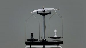 Chess pieces balanced on a scale depicting equality or strategy in decision making.
